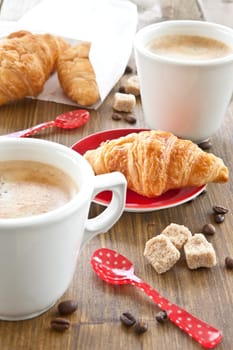 Cups with coffee and fresh croissants