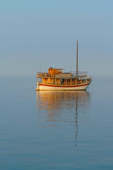 Small traditional Adriatic sailboat  moored in calm sea. Shooted at the "golden hour"""