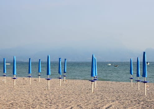 Closed parasols at rubble beach in the morning