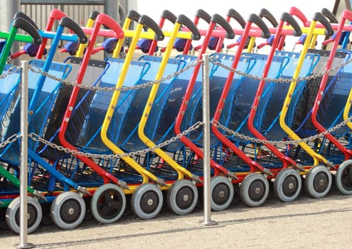 A line of colorful shopping carts in daylight