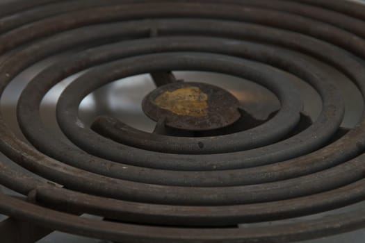 A coiled electric heating element on a modern stove up close.