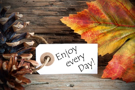 An Autumn Label with the Words Enjoy every Day, on Wood