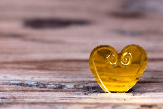 A Golden Heart on Wood as Background with Copy Space