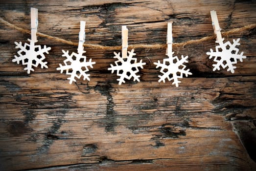 Christmas or Winter Background with Snowflakes on a Line on Wood