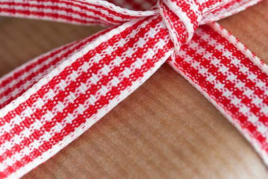 Closeup of a Red White Gift Ribbon on a Brown Present