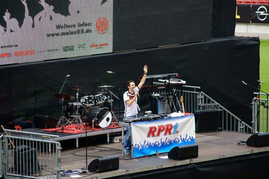 Mainz,Germany – June 26,2014: A moderator at the public viewing of the 2014 World Cup stands on stage and heats up the crowd on June 26,2014 in Mainz.