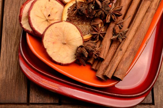 Different herbs and dried fruits on a ceramic plate
