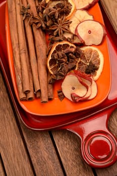 Different herbs and dried fruits on a ceramic plate