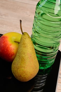 Fresh fruits and a bottle of water on a scale