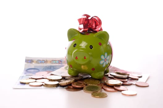 Green piggy bank on money with a white background