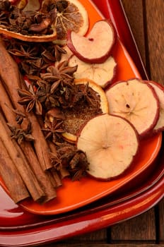 Different herbs and dried fruits on a ceramic plate