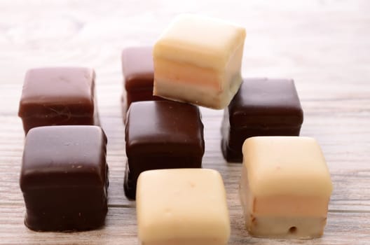 Sweet chocolate dices on a wooden table
