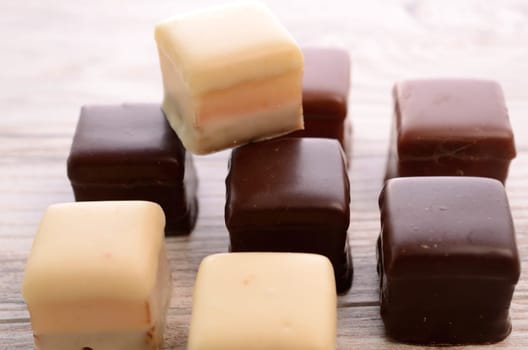Sweet chocolate dices on a wooden table