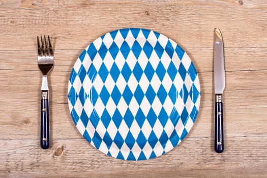 Knife and fork with plate in blue and white on rustic table