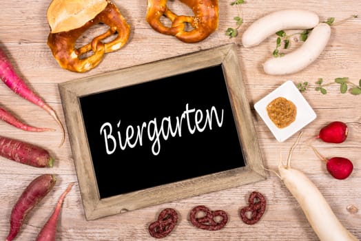 Sign with a table beer garden with sausage,radish and pretzels