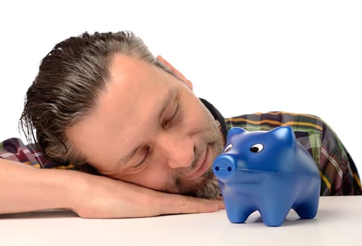 Sleeping man with a blue piggy bank,financial concept