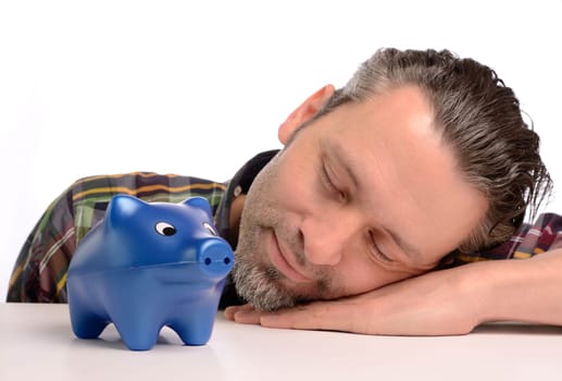 Sleeping man with a blue piggy bank,financial concept