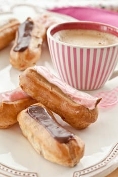 Selection of small eclairs with a cup of espresso