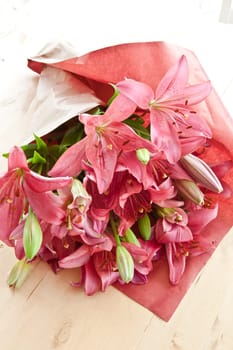 Fresh pink lilies as bouquet of flowers smashed into paper