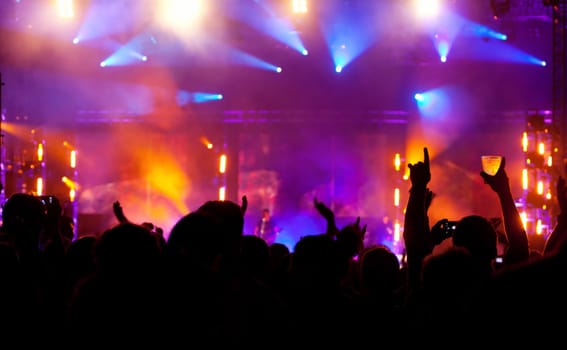 Cheering crowd in front of bright colorful stage lights