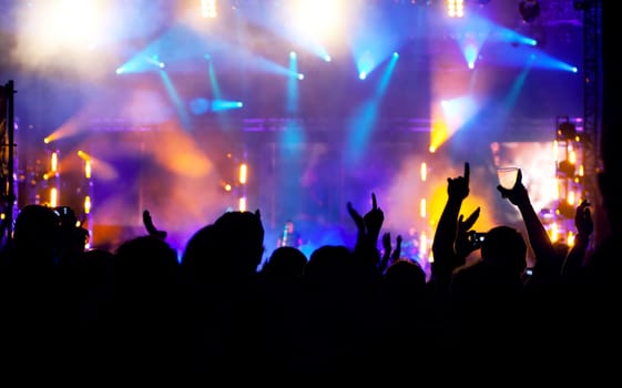 Cheering crowd in front of bright colorful stage lights