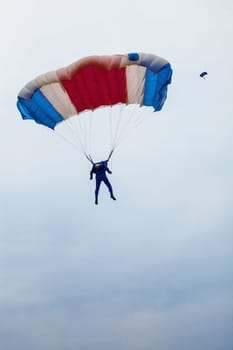 Male parachutist under a multi-coloured parachute