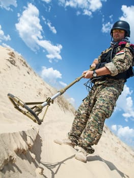iraqi soldier in the desert with army metal detector