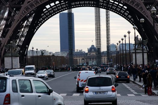 Paris,France – December 29,2013: Traffic and tourists and crowds under the Eiffel Tower on December 29,2013 in Paris.