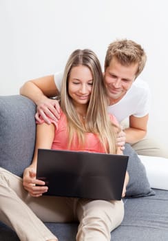 Happy couple shopping online from the comfort of their home