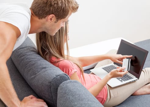 Happy couple shopping online from the comfort of their home