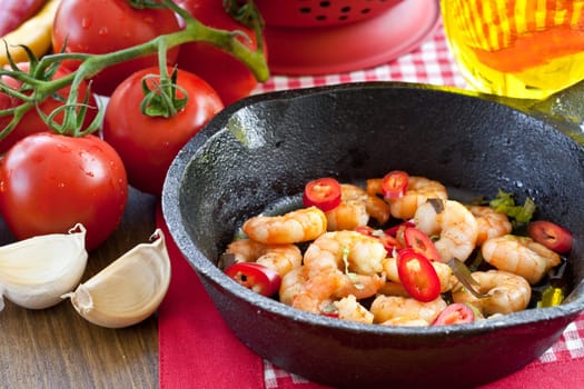Fried shrimp with chilli in cast iron pan