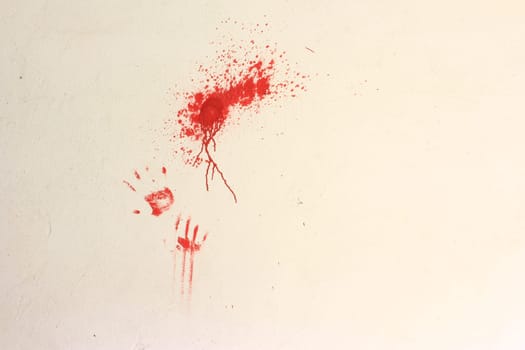 Color smudders and imprints of hands with red color on a bright wall