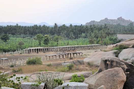 Ancient ruins of Vijayanagara Empire at sunset blue sky in Hampi, Karnataka, India