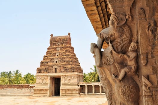 Ancient partiallyovergrown ruins of Vijayanagara Empire at sunset blue sky in Hampi, Karnataka, India