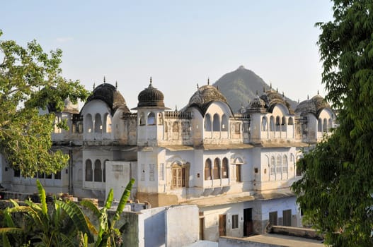 Typical traditional architecture in the holy Hindu city of Pushkar, Rajasthan, India with mountain temple in bakcground