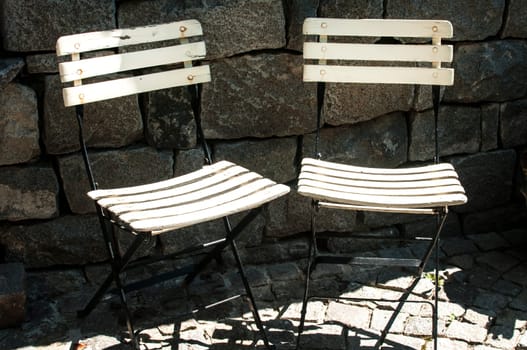 Two vintage folding chairs on stone background