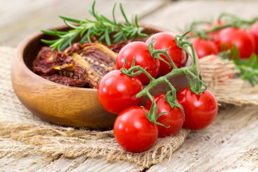 fresh and dried tomatoes on wooden background