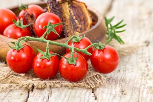 fresh and dried tomatoes on wooden background