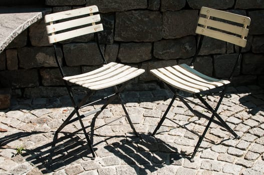 Two vintage folding chairs on stone background