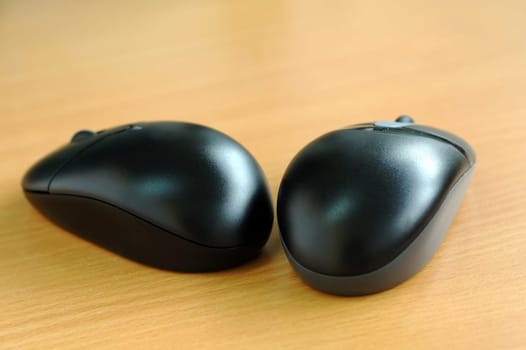 Two black computer wireless mices on desk
