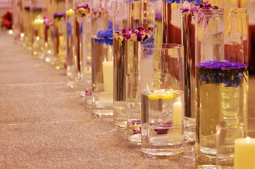 A row of different vases with flowers and candles
