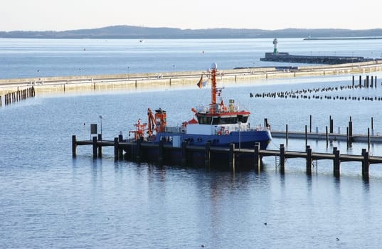 A photograph of a fishing boat in a harbour area of the Baltic Sea.