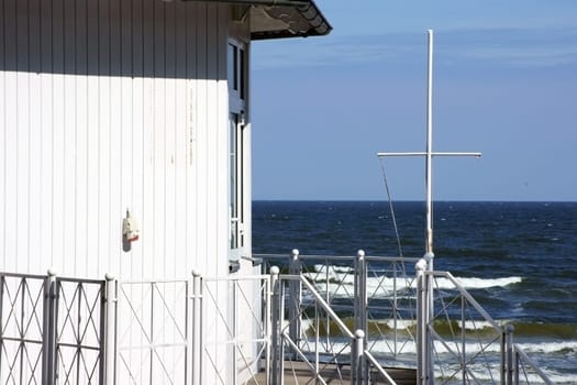 The photograph of a guardhouse on the Baltic Sea with waves and beautiful weather.