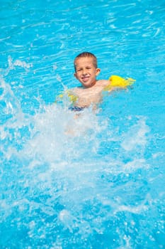 Happy boy with water rings have a fun in swimming pool