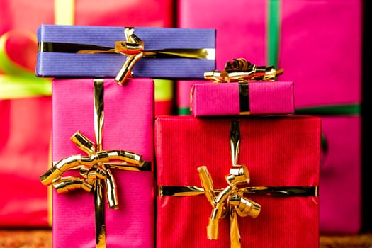 Plain presents in vibrant magenta, crimson and blue wrapping. Flattened space via tight framing. Background for any gift-giving occasion..