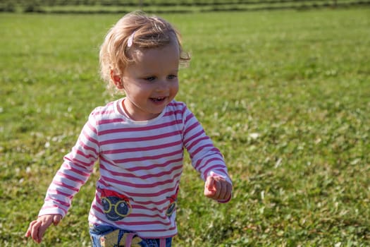 little girl runs laughing across a meadow