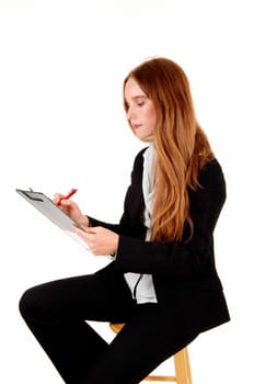 A lovely young business woman sitting and holding a clipboard and writing .on, isolated for white background..