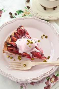 Cake with fresh plums with a scoop of ice cream and a cup of coffee