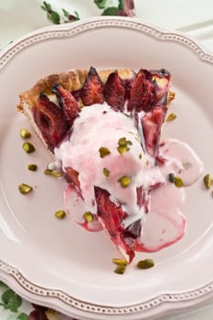Stueck plum cake with a melted ball of ice cream