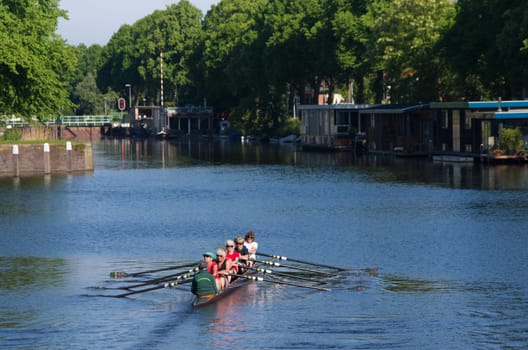 femele senior rowers in a canoe on a canal in the netherlands